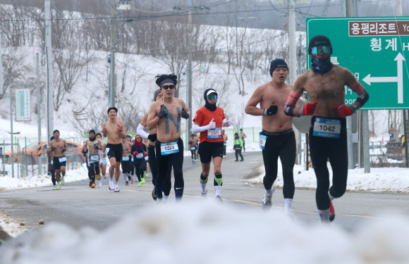 1일 강원 평창군 대관령에 열린 ‘2025 평창 대관령 알몸 마라톤 대회’ 참가자들이 눈 쌓인 대관령 일원의 도로를 달리고 있다.  이 대회는 남자는 상의 탈의, 여성은 민소매나 반소매 티를 입어야 하는 복장 규정이 있다. 2025.2.1  연합뉴스