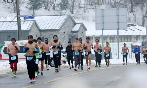 1일 강원 평창군 대관령에 열린 ‘2025 평창 대관령 알몸 마라톤 대회’ 참가자들이 눈 쌓인 대관령 일원의 도로를 달리고 있다.  이 대회는 남자는 상의 탈의, 여성은 민소매나 반소매 티를 입어야 하는 복장 규정이 있다. 2025.2.1  연합뉴스