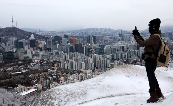 삼일절 연휴 마지막 날인 3일 서울 인왕산에서 한 시민이 사진을 촬영하고 있다. 이날 서울은 1㎝ 내외의 눈과 강풍이 예보됐다. 2025.3.3  연합뉴스