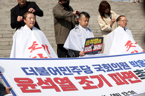 11일 서울 여의도 국회 본청 앞 계단에서 더불어민주당 전진숙(왼쪽부터), 박홍배, 김문수 의원이 윤석열 대통령 조기파면 등을 촉구하며 삭발하고 있다. 2025.3.11  연합뉴스