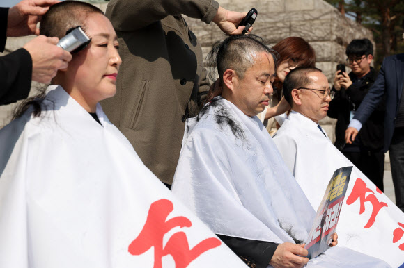 11일 서울 여의도 국회 본청 앞 계단에서 더불어민주당 전진숙(왼쪽부터), 박홍배, 김문수 의원이 윤석열 대통령 조기파면 등을 촉구하며 삭발하고 있다. 2025.3.11  연합뉴스