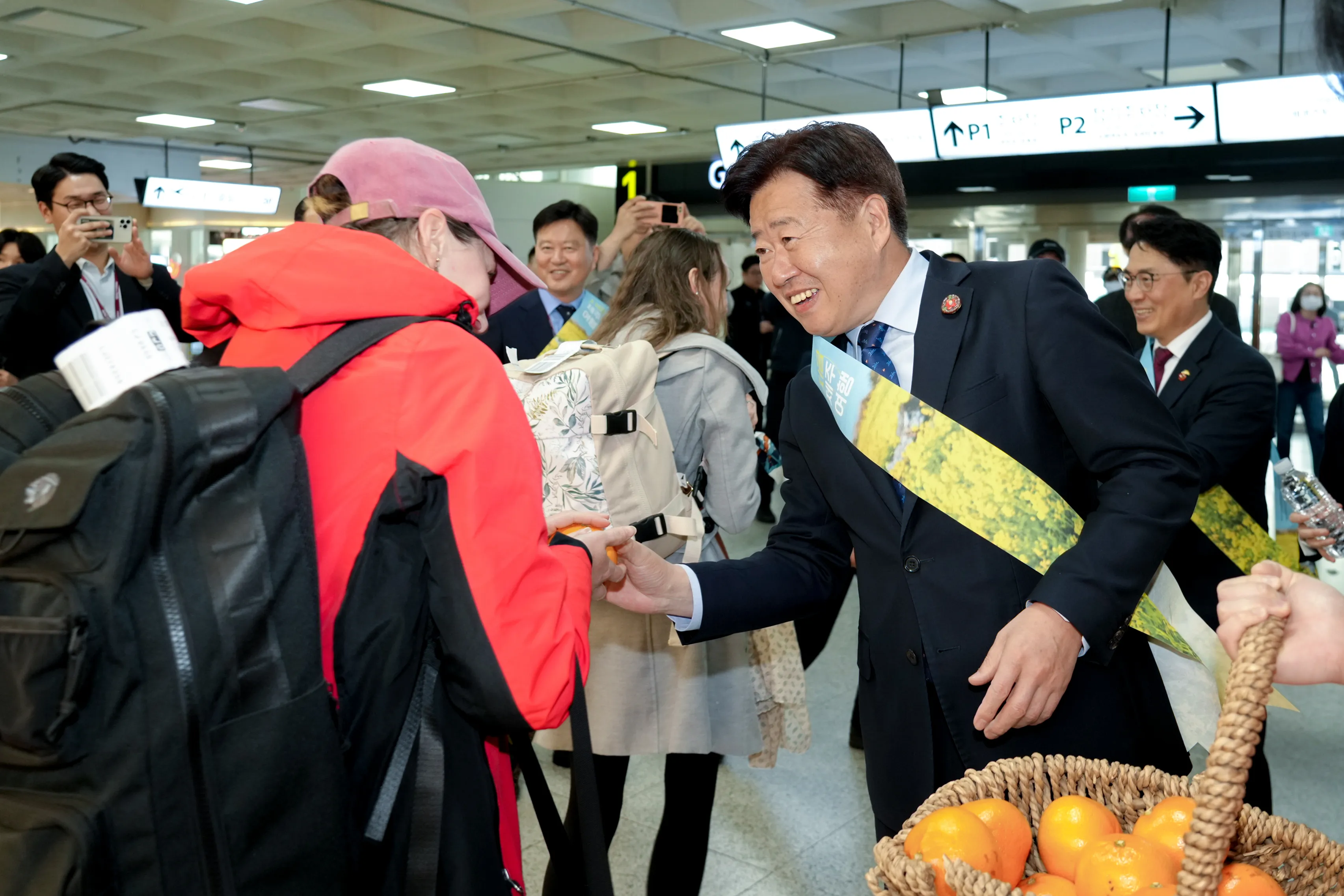오영훈 지사가 28일 제주국제공항 봄 관광시즌 개막을 알리는 ‘제주에 폭싹 빠졌수다’ 환영행사에서 여행객들에게 귤을 직접 나눠주며 환영하고 있다. 제주도 제공