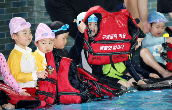 세월호 참사 11주기를 하루 앞둔 15일 오후 제주시 연동의 한 수영장에서 해오름어린이집 만 6∼7세 아동 25명의 어린이가 제주해양경찰서 구조대원과 수영강사 등으로부터 생존수영을 배우고 있다. 2025.4.15. 연합뉴스