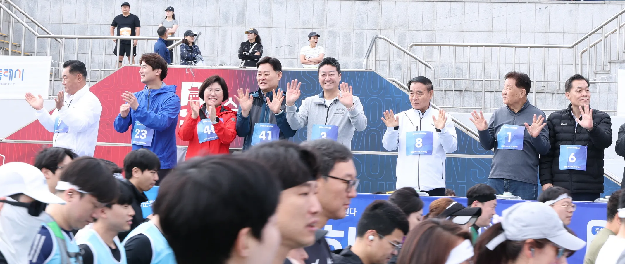 김진경 의장(중앙 회색 상의)과 황대호 도의원(왼쪽 두 번째), 이애형 도의원(왼쪽에서 세 번째)을 비롯한 각계 인사들이 출발하는 마라토너들을 향해 박수를 치며 응원하고 있다.