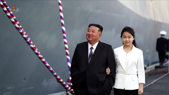 북한 조선중앙TV는 북한 김정은 국무위원장이 참석한 가운데 5,000t급 신형다목적구축함 ‘최현호’ 진수식이 지난 25일 남포조선소에서 진행됐다고 26일 보도했다. 배에 오른 김정은과 딸 주애가 팔짱을 낀채 구내를 돌아보고 있다.2025.4.26  연합뉴스