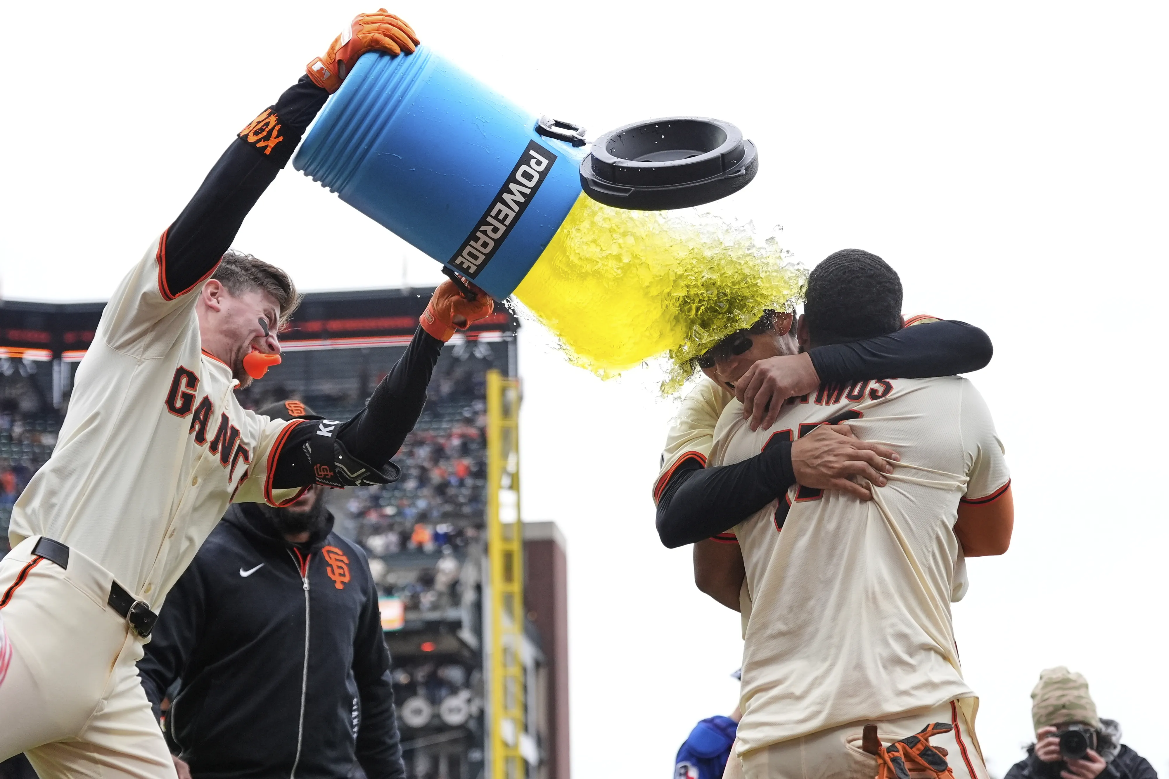 9회 말 엘리오트 라모스의 끝내기 득점 직후 이정후(가운데)를 끌어 안고 승리를 자축하고 있는 라모스(왼쪽)에게 팀 동료 크리스천 코스가 음료수를 통째 퍼붓고 있다. 샌프란시스코 AP 연합뉴스