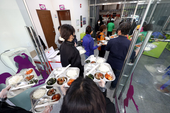 대구 대형 산불 발생 이틀째인 29일 대구 북구 팔달초등학교에 설치된 대피소에서 봉사자들과 공무원이 아침 식사를 옮기고 있다. 2025.4.29 연합뉴스