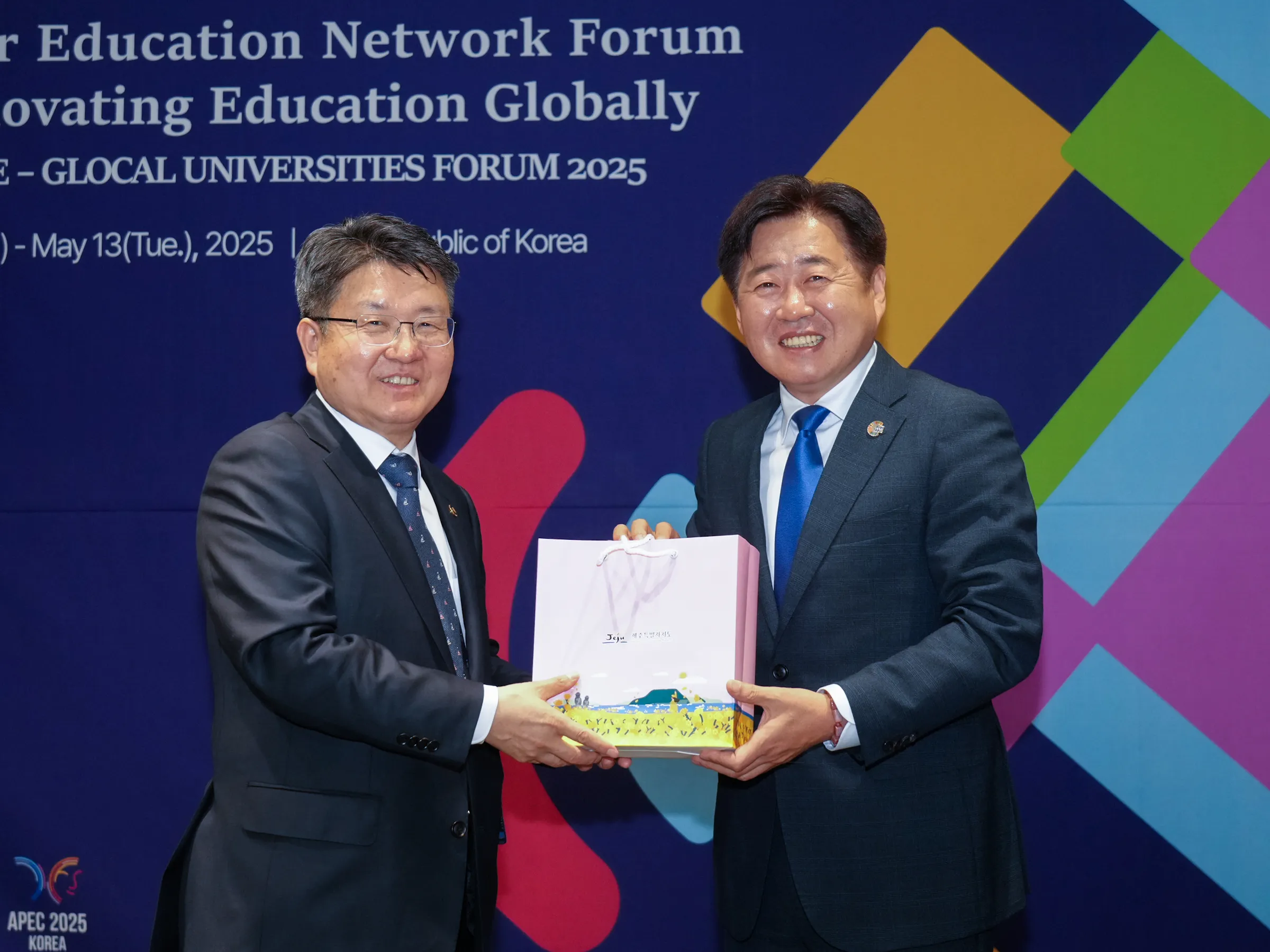 오영훈 제주지사와 오석환(왼쪽) 교육부 차관이 12일 부영호텔에서 열린 글로벌교육혁신 고등교육 네트워크포럼에서 런케이션을 공유하는 면담을 가진 뒤  오 지사가 오 차관에게 제주 화장품을 기념으로 전달하며 포즈를 취하고 있다. 제주도 제공