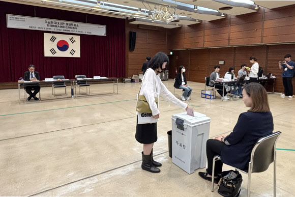 제21대 대통령 선거 재외투표 첫날인 20일 일본 도쿄 미나토구 주일한국대사관에 마련된 재외투표소에서 유권자가 투표함에 투표용지를 넣고 있다. 2025.5.20  연합뉴스