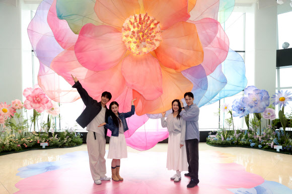 20일 서울 송파구 롯데월드타워 전망대 서울스카이에서 모델들이 플라워 체험형 공간 ‘블루밍 유니버스: 빅 플라워’를 즐기고 있다.  2025.5.20  연합뉴스