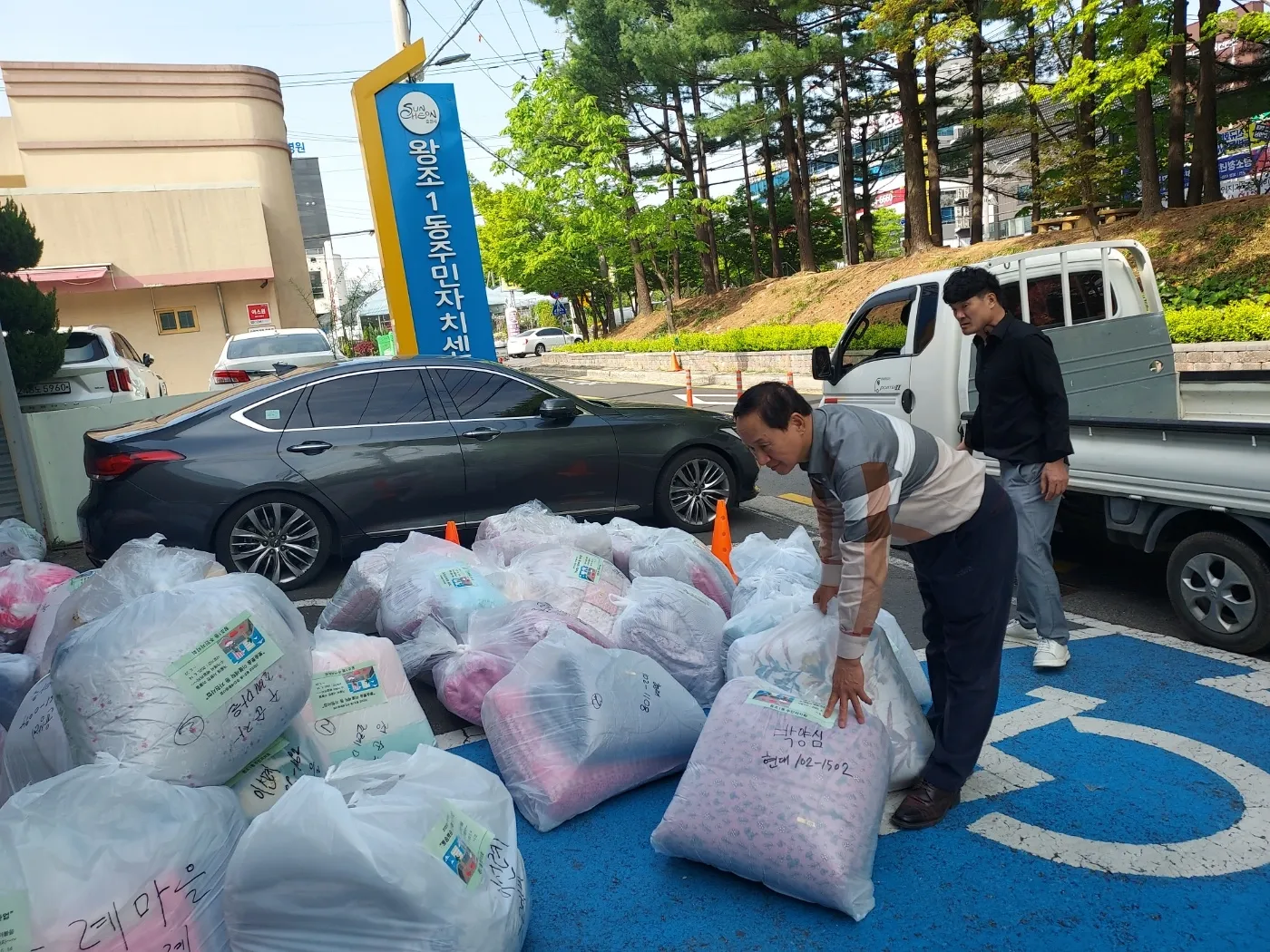 순천시 왕조1동 주민자치회가 세탁한 이불을 차에 싣기 위해 분류하고 있다.
