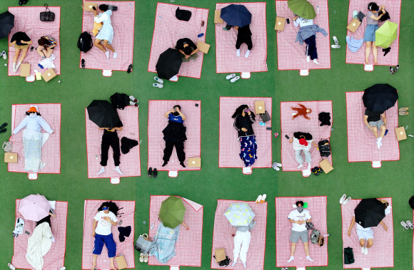 21일 오후 광주 동구 조선대학교 운동장에서 열린 대놓고 잠자기 대회에서 시민과 학생 참가자들이 낮잠을 자고 있다. 2025.5.21. 연합뉴스