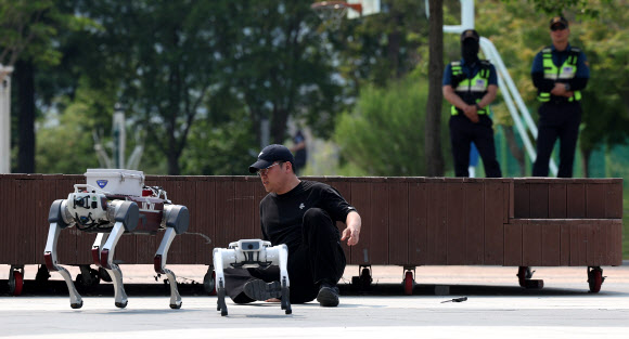 28일 오후 대구 수성구 수성못에서 열린 대구경찰청의 AI드론·로봇을 이용한 디지털 합동 순찰 시연에서 폴리봇(순찰로봇) 2대가 성추행용의자와 대치하고 있다. 2025.5.28. 연합뉴스