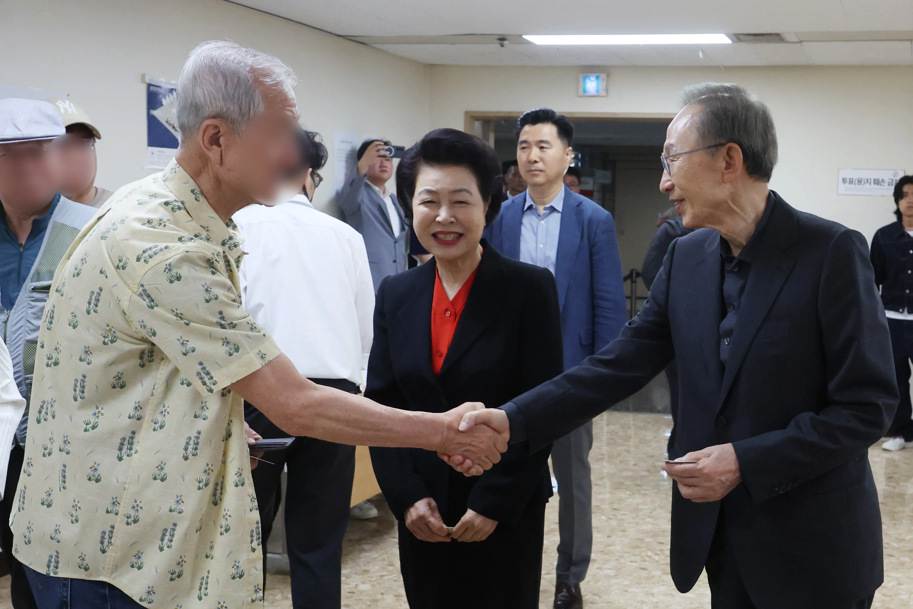유권자와 인사 나누는 이명박 전 대통령  이명박 전 대통령이 제21대 대통령선거 투표일인 3일 서울 강남구 국민연금공단 서울남부지역본부에 마련된 논현1동제3투표소에서 유권자와 악수를 나누고 있다. 가운데는 이 전 대통령 부인 김윤옥 여사. 2025.6.3 연합뉴스