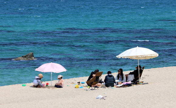 제21대 대통령 선거일인 3일 강원 강릉시 경포해변에 투표를 마치고 나들이 나온 시민과 관광객들이 휴식을 취하고 있다. 2025.6.3 연합뉴스