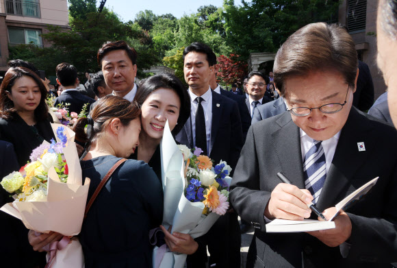 이재명 대통령이 4일 인천 계양구 사저를 출발하기 전 한 지지자가 준비한 자신의 자서전에 서명하고 있다. 2025.6.4  연합뉴스