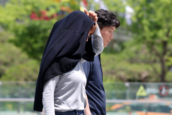 초여름 날씨를 보인 5일 서울 종로구 광화문광장에 한 시민이 외투를 머리에 뒤집어쓴 채 더위를 피하고 있다. 2025.6.5. 연합뉴스