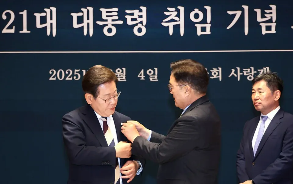 우원식 국회의장이 6월 4일 서울 국회 사랑재에서 열린 제21대 대통령 취임 기념 오찬에서 이재명 대통령에게 ‘진관사 태극기’를 달아주고 있다. 우원식 국회의장 페이스북