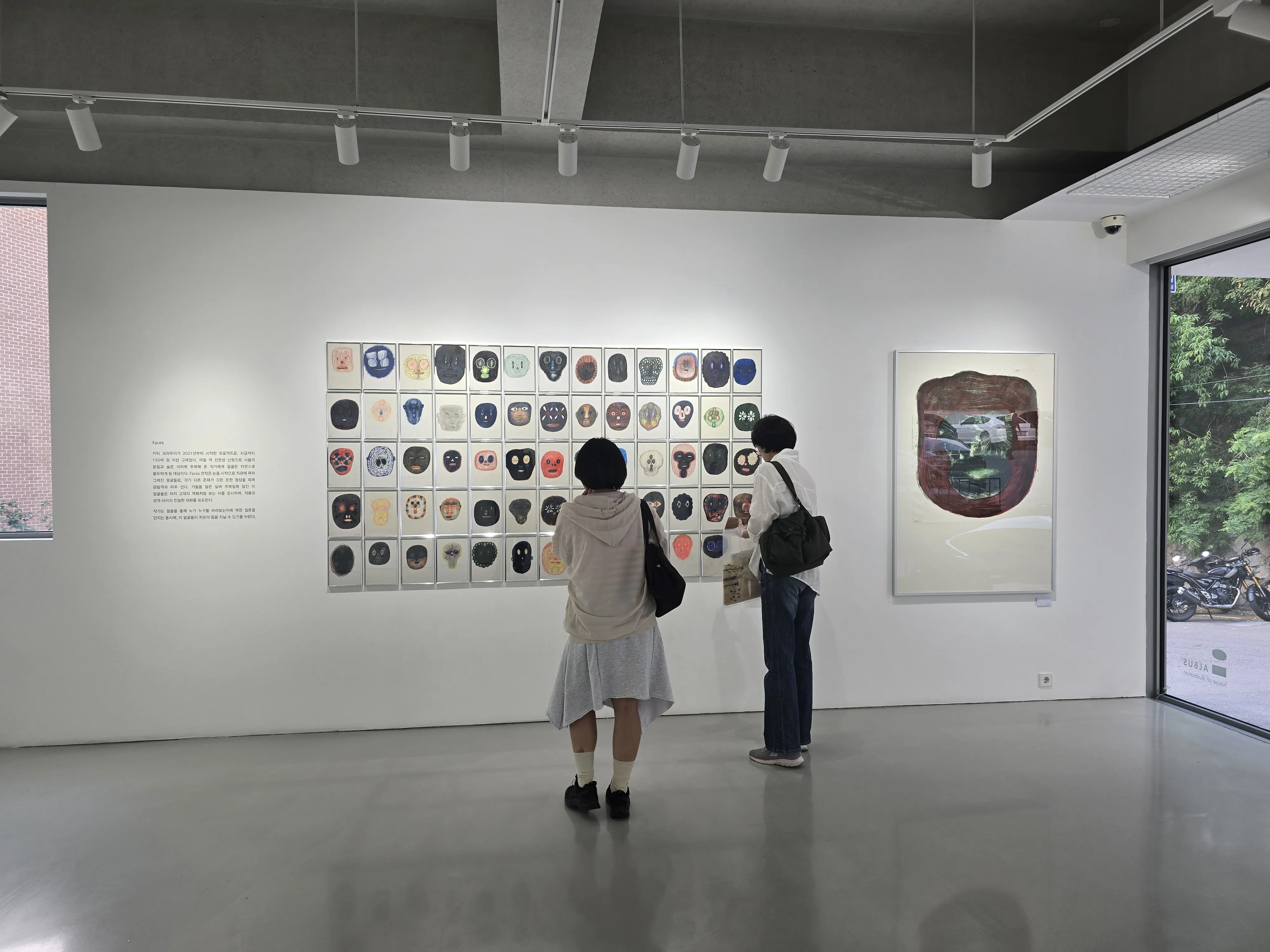 크라우더의 ‘얼굴들’ 연작을 감상하는 관람객의 모습. 이 작품은 그림책의 경계를 넘어 현대 미술로 확장한 크라우더의 예술적 도전을 보여 준다.