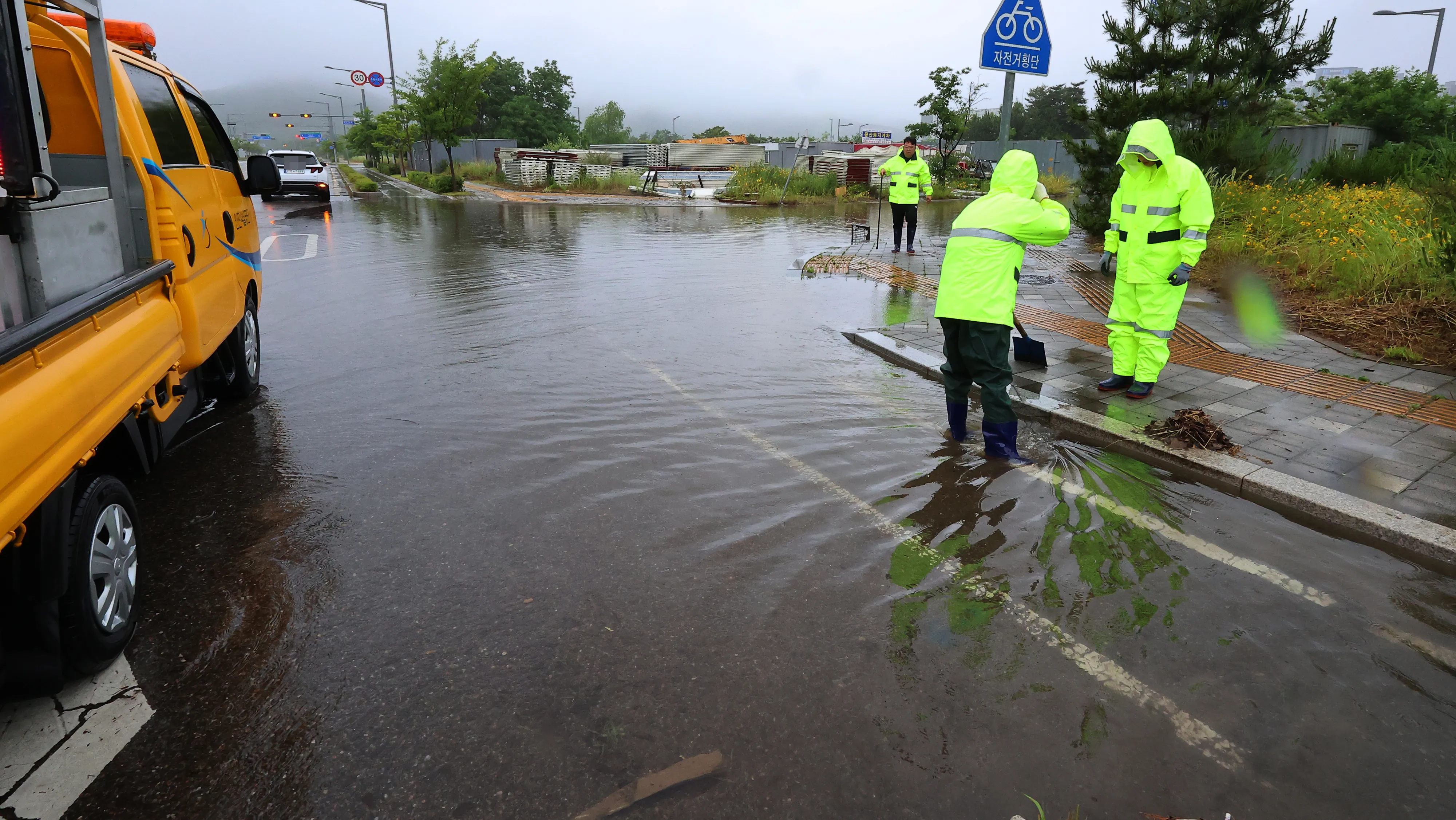 인천 중구 운남동의 한 도로에서 인천시설공단 관계자들이 장맛비에 침수된 도로의 빗물받이에 쌓인 낙엽 등을 청소하고 있다. 연합뉴스