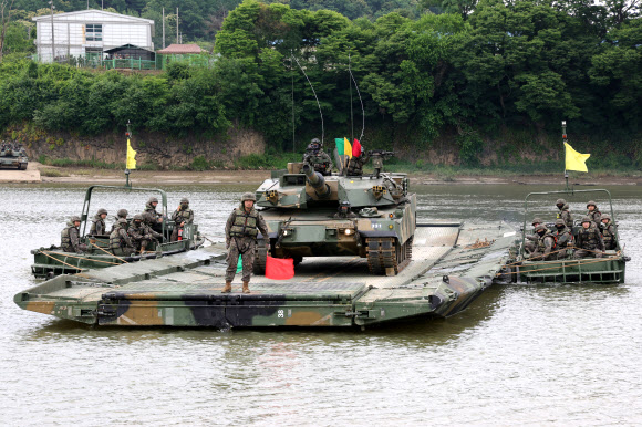 24일 경기도 파주시 임진강에서 실시된 육군 1군단 도하훈련에서 육군 2기갑여단 K1A2 전차가 1공병여단의 문교를 이용해 강을 건너고 있다.  이날 훈련에는 1군단 예하 2기갑여단과 1공병여단, 11화생방대대 등이 참여해 K1A2 전차와 K200A1 장갑차가 임진강을 건너 목표 지점에 도달하는 내용으로 진행됐다. 2025.6.24  연합뉴스