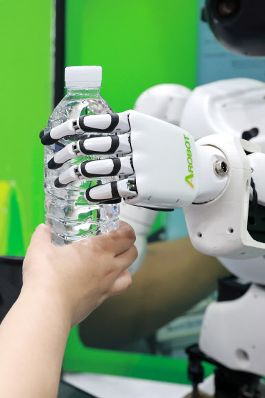 26일 서울 강남구 코엑스에서 개막한 벤처·스타트업 박람회 ‘넥스트라이즈 2025’에서 휴머노이드 로봇 ‘앨리스 4’가 관람객과 주사위 게임을 한 뒤 상품으로 물을 전달하고 있다. 2025.6.26 연합뉴스