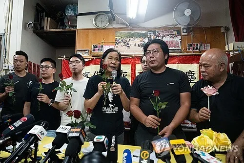 민주화 운동가 찬포잉(왼쪽 네번째)이 29일 장미꽃을 든 채 홍콩의 마지막 민주 정당인 사회민주당의 해산을 발표하고 있다. 홍콩 로이터 연합뉴스
