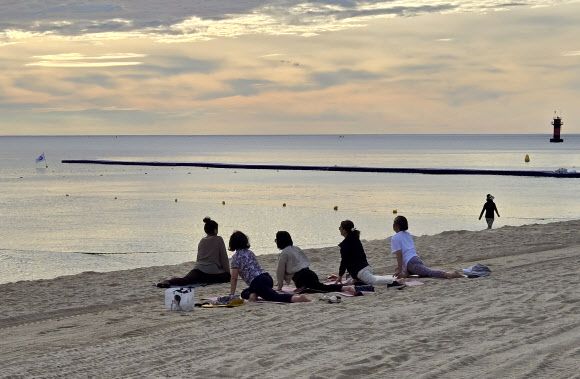 강원 강릉지역이 폭염경보 속에 이틀 연속 열대야를 기록한 1일 경포해변 백사장에서 주민들이 요가하며 열대야의 아침을 맞고 있다. 밤사이 강릉의 최저기온은 29.7도를 기록했다. 2025.7.1  연합뉴스
