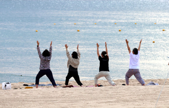 강원 강릉지역이 폭염경보 속에 이틀 연속 열대야를 기록한 1일 경포해변 백사장에서 주민들이 요가하며 열대야의 아침을 맞고 있다. 밤사이 강릉의 최저기온은 29.7도를 기록했다. 2025.7.1  연합뉴스