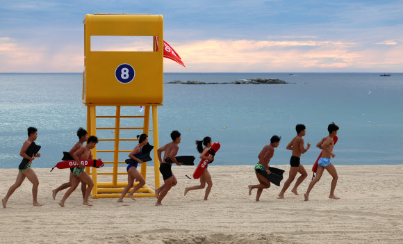 강원 강릉지역이 폭염경보 속에 이틀 연속 열대야를 기록한 1일 아침 경포해변 백사장에서 수상안전요원들이 러닝을 하며 열대야의 아침을 맞고 있다. 밤사이 강릉의 최저기온은 29.7도를 기록했다. 2025.7.1  연합뉴스