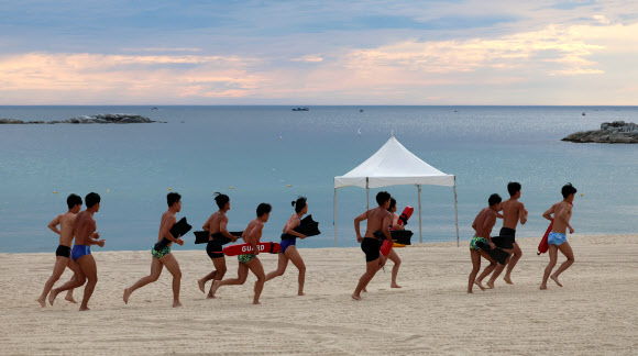 강원 강릉지역이 폭염경보 속에 이틀 연속 열대야를 기록한 1일 아침 경포해변 백사장에서 수상안전요원들이 러닝을 하며 열대야의 아침을 맞고 있다. 밤사이 강릉의 최저기온은 29.7도를 기록했다. 2025.7.1  연합뉴스