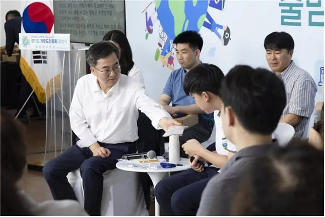 김동연 경기도지사가 지난달 30일 시흥에코센터에서 진행된 <경기도 기후도민총회 출범식>에서 땀 흘리는 학생 참가자에게 손수건을 건네고 있다. (경기도 제공)