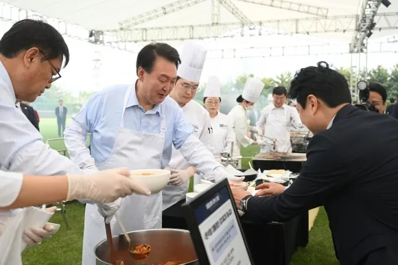 대통령의 저녁 초대, 앞치마 입은 윤석열 대통령  윤석열 대통령이 24일 서울 용산 대통령실 청사 잔디마당에서 열린 ‘대통령의 저녁 초대’ 출입기자단 초청 만찬 간담회에서 김치찌개를 배식하고 있다. 2024.5.24 연합뉴스