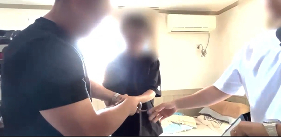 경찰이 16년 전 동거녀를 살해한 혐의로 50대 남성을 체포하고 있다. 경남경찰청 제공