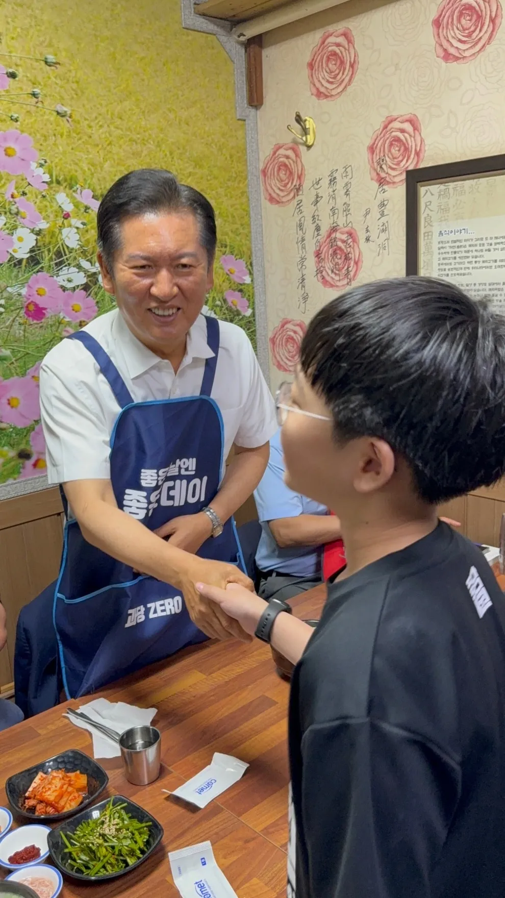 불꽃 튀는 당심 경쟁  더불어민주당 당대표 선거에 출마한 정청래 의원이 지난 5일 당원간담회를 진행한 경남 창원시 대동상가의 국밥집에서 한 어린이와 악수하는 모습.
정청래 의원 페이스북 캡처