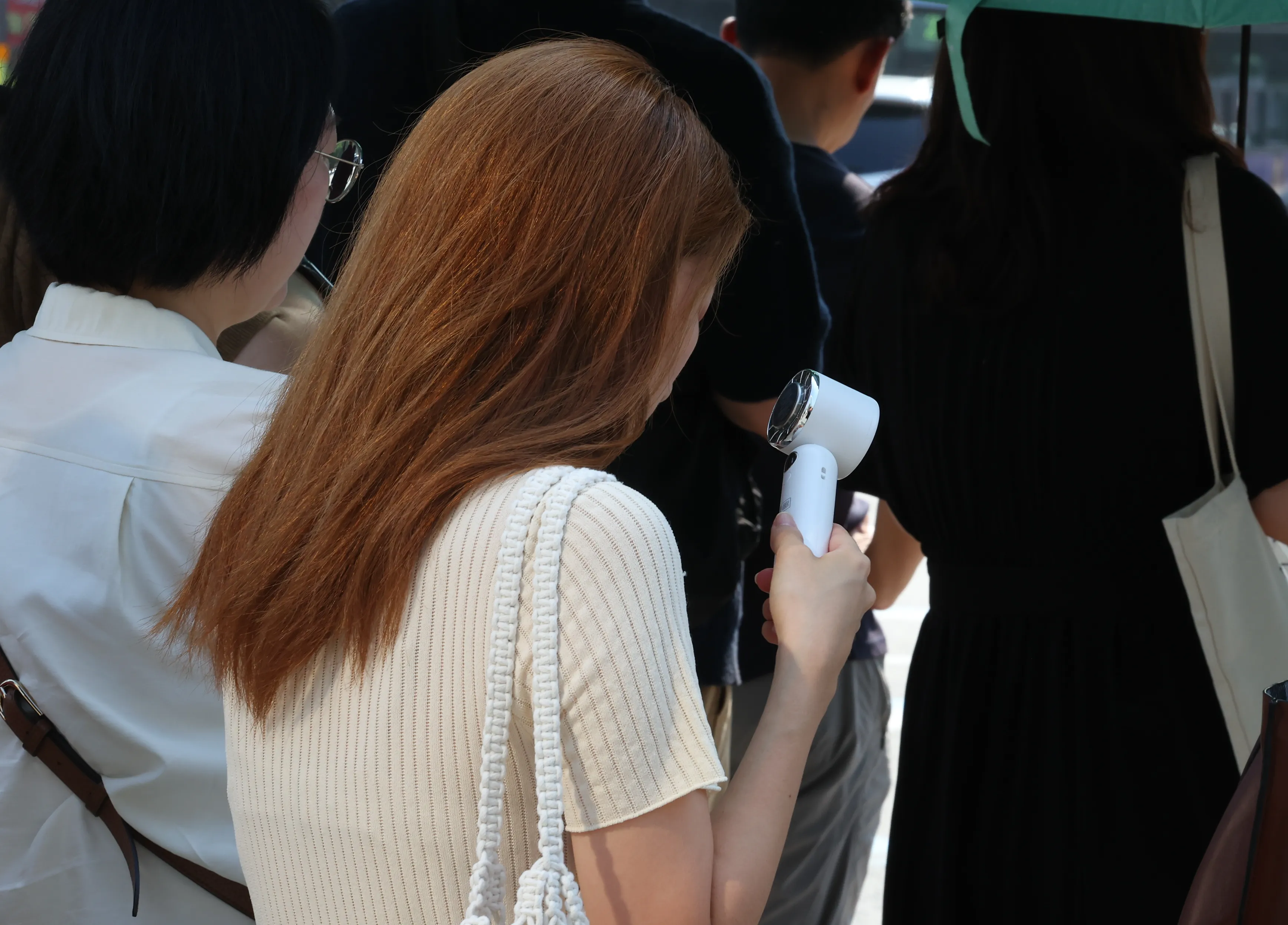 오늘도 덥다 더워  폭염이 이어지고 있는 8일 서울 세종대로사거리 인근에서 한 시민이 손 선풍기를 틀고 더위를 식히며 출근길 발걸음을 재촉하고 있다. 2025.7.8 뉴시스