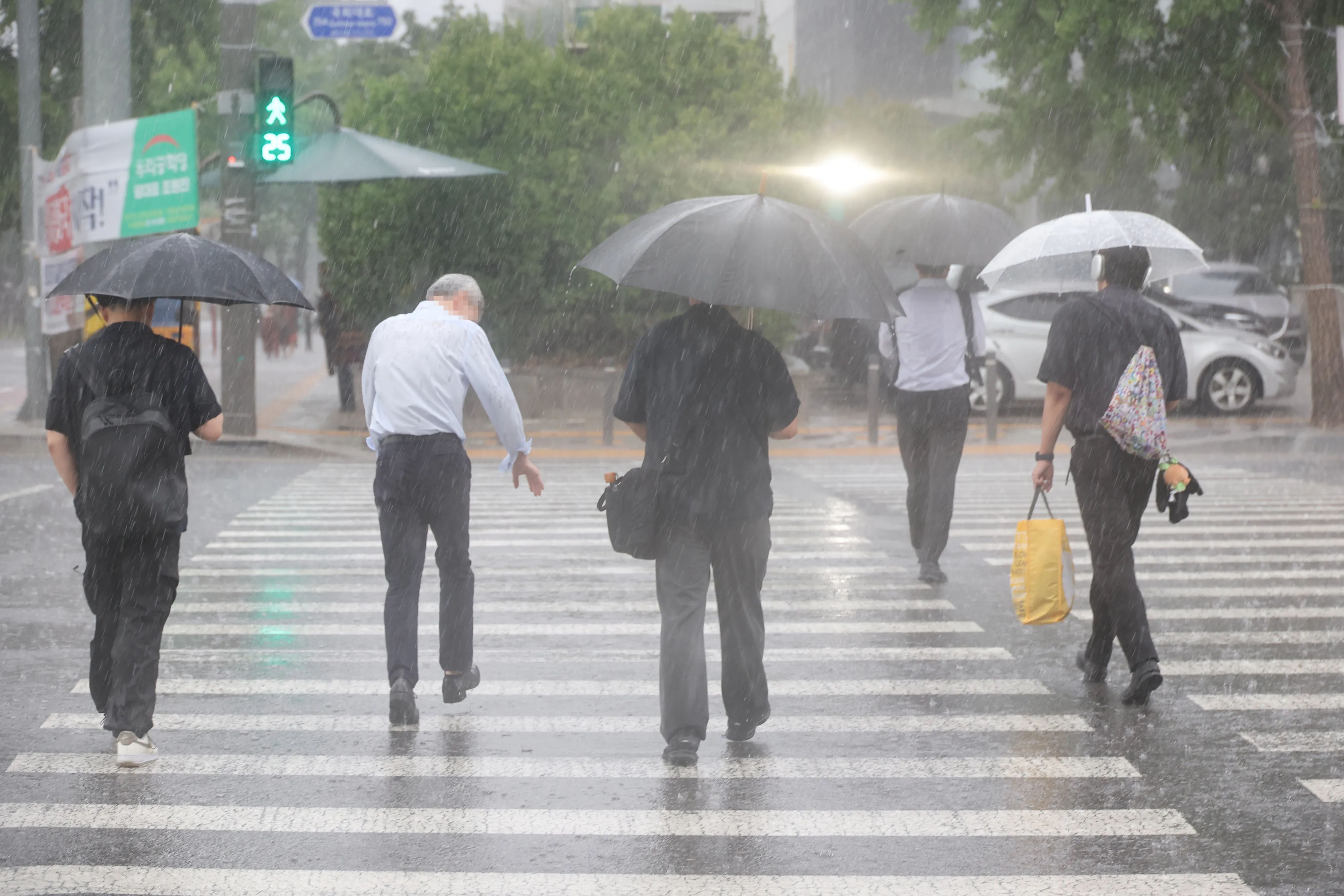 퇴근길 폭우  서울 서남권에 호우주의보가 발효된 8일 서울 영등포구 여의도 국회 인근에서 시민들이 우산을 쓰고 이동하고 있다. 2025.7.8 연합뉴스
