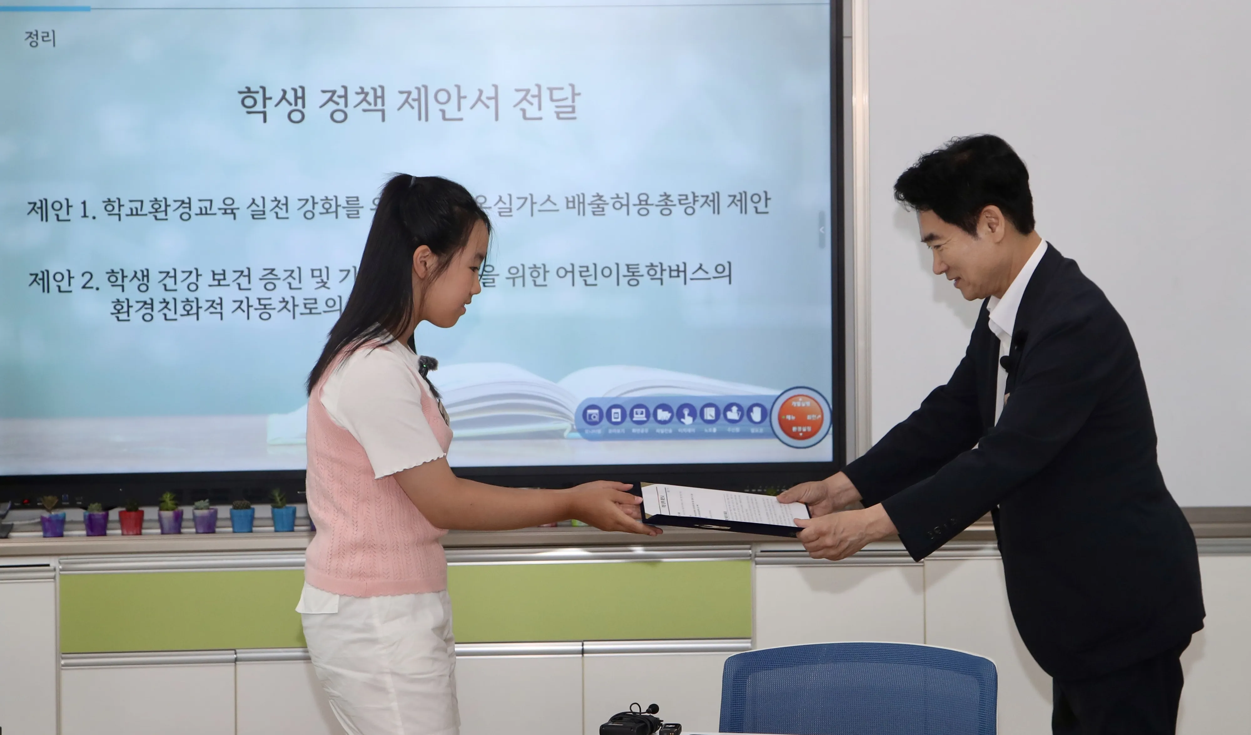 화순오성초 한 학생이 지구의 미래를 지키기 위한 약속과 정책 제안서를 김대중 전남교육감에게 전달하고 있다.