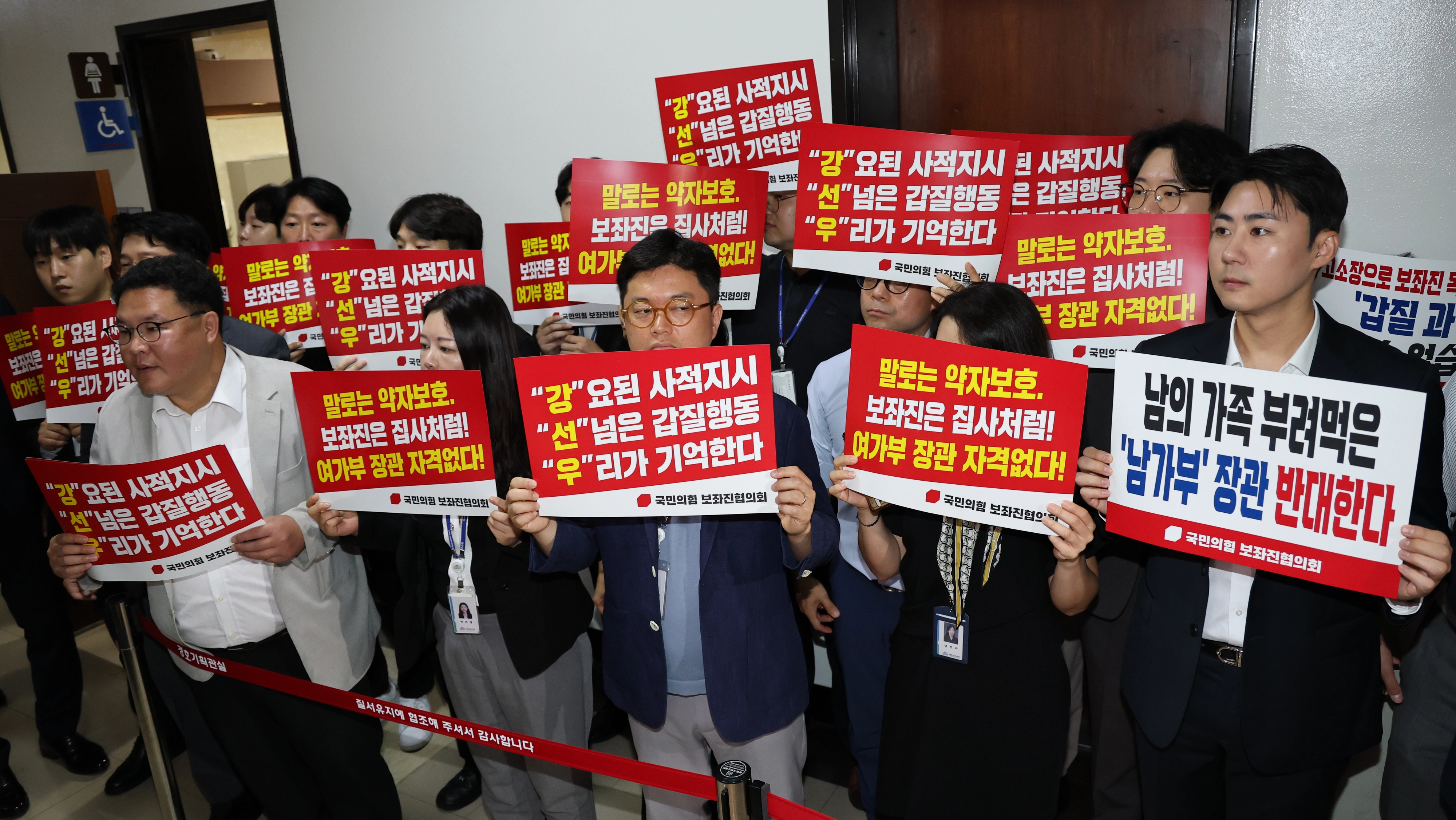 국민의힘 보좌진협의회 보좌관들이 14일 서울 여의도 국회에서 열리는 강선우 여성가족부 장관 후보자 인사청문회장 앞에서 강  후보자를 규탄하는 손팻말을 들고 있다. 뉴스1