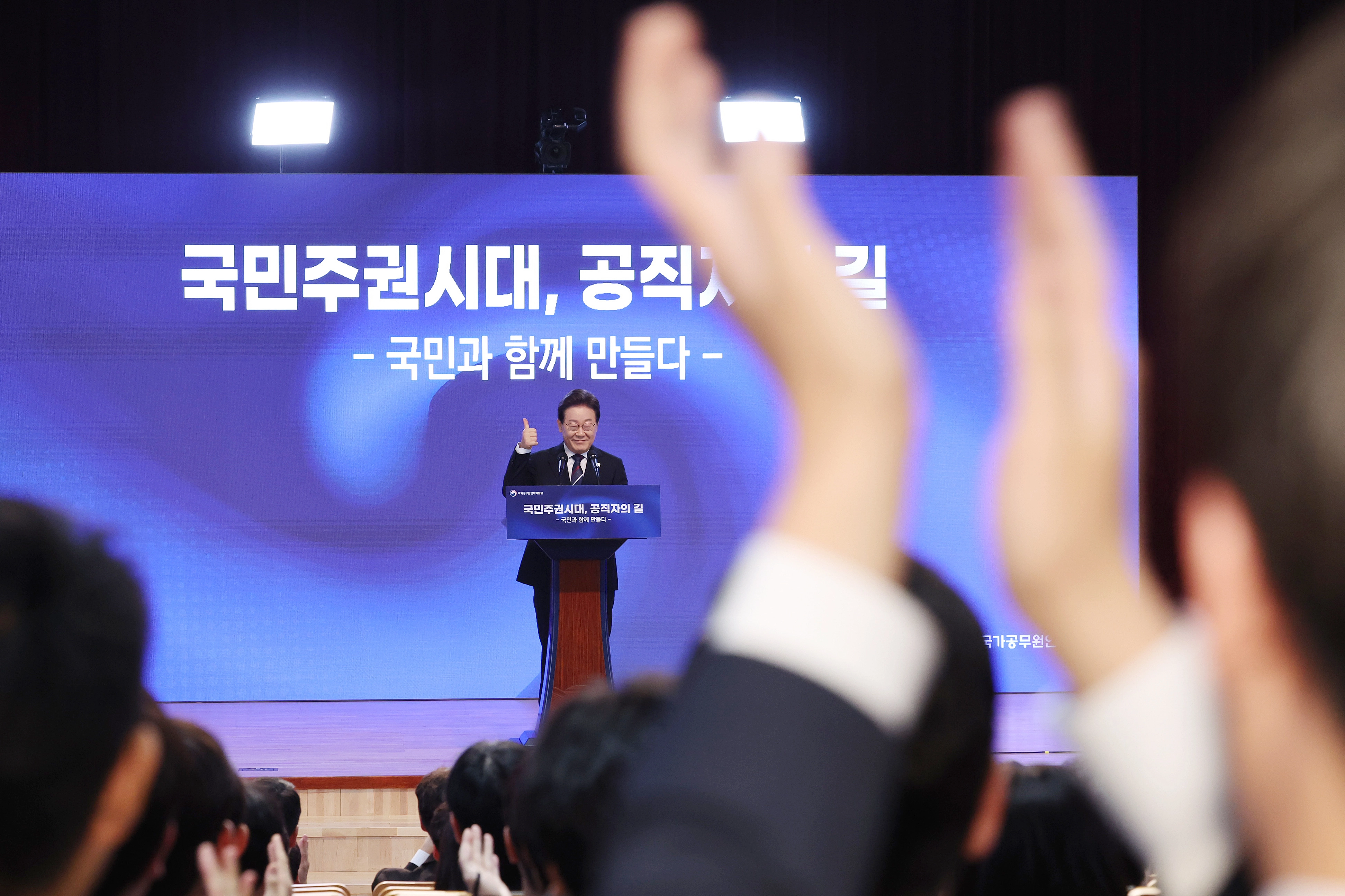 예비 공무원 박수에 화답하는 이재명 대통령  이재명 대통령이 14일 충북 진천 국가공무원인재개발원에서 ‘국민주권시대, 공직자의 길’을 주제로 열린 70기 5급 신임관리자과정 교육생 특강에서 연단에 올라 참석자들의 박수에 화답하고 있다. 2025.7.14 연합뉴스