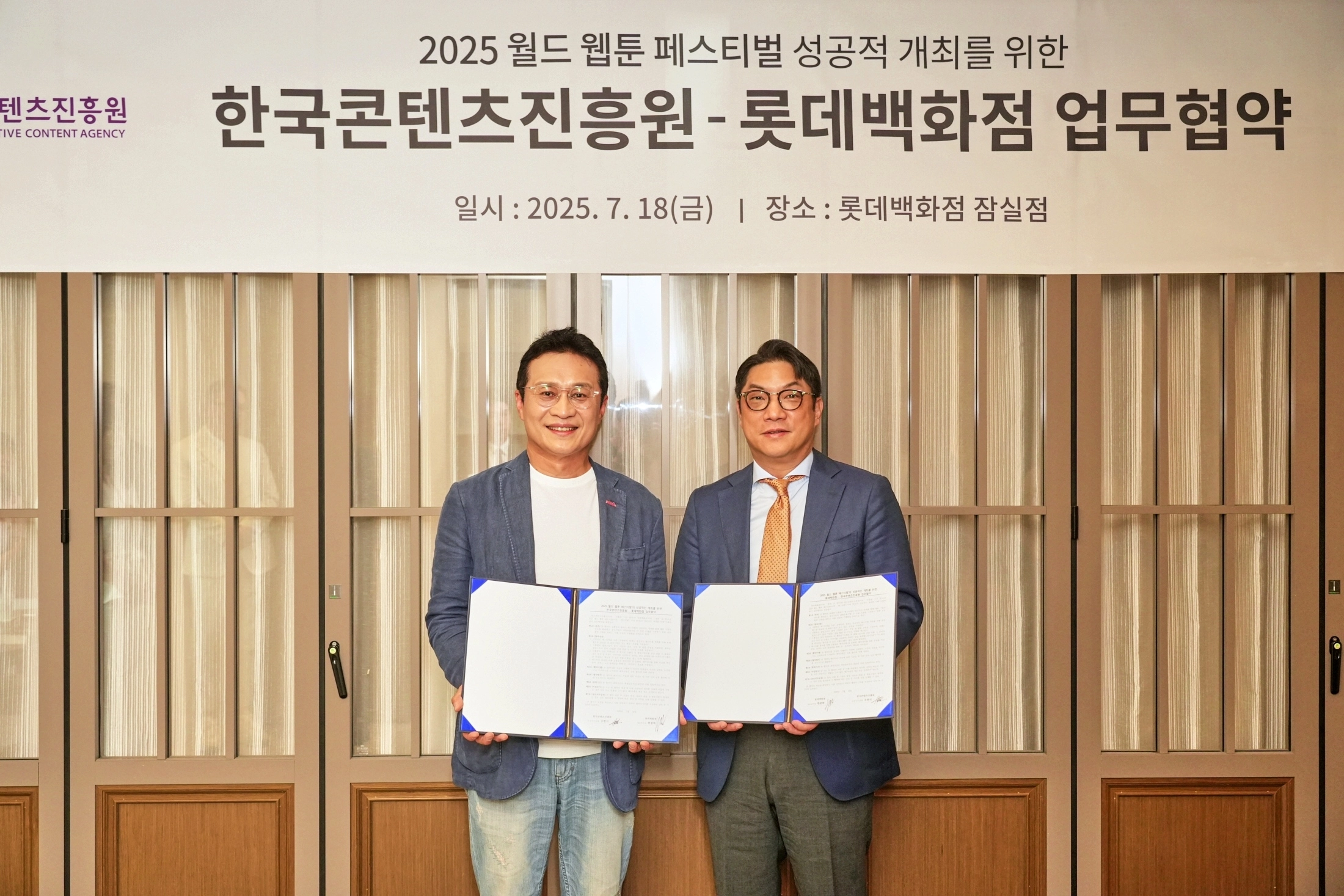 유현석(왼쪽) 한국콘텐츠진흥원 원장직무대행과 현종혁 롯데백화점 MD본부장이 18일 ‘2025 월드 웹툰 페스티벌’ 업무협약 체결 후 서약서를 들고 있다. 롯데백화점 제공