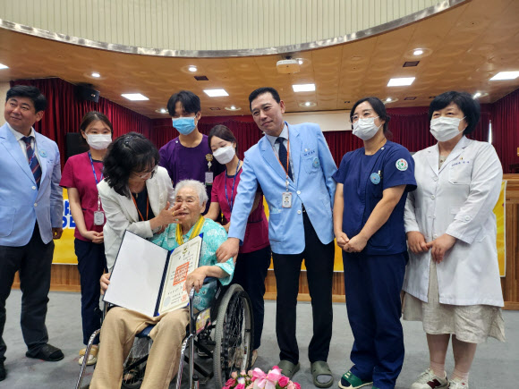 2일 오전 광주 동구 한 요양병원에서 일제 강제동원 피해자 양금덕 할머니(94)가 국민훈장 모란장을 받은 뒤 기념사진을 찍고 있다. 2025.8.2. 국가인권위원회광주사무소제공