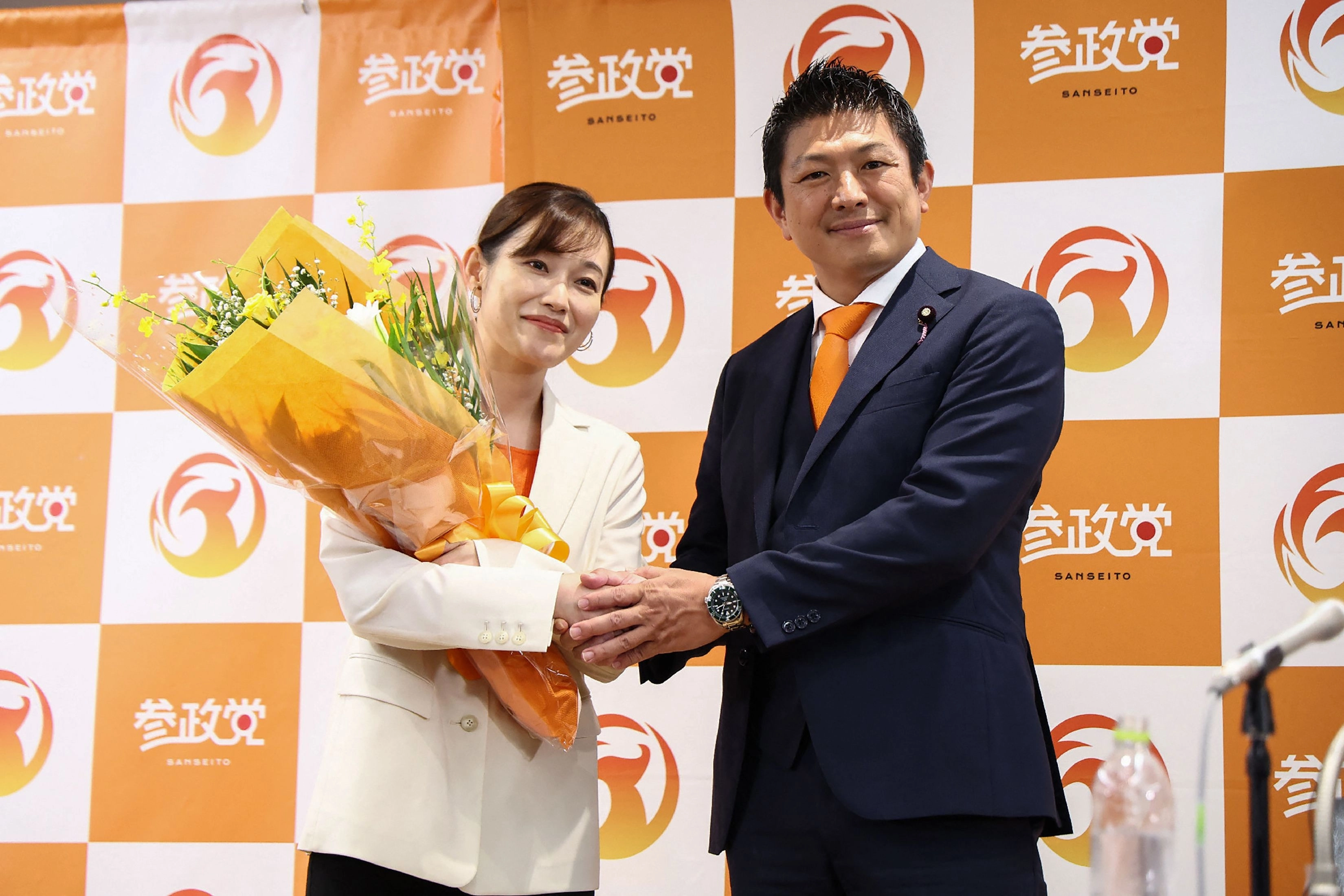 가미야(오른쪽) 대표가 참의원 선거가 치러진 지난달 20일 도쿄 개표소에서 당선인 사야 의원과 악수하고 있다. ﻿ AFP 연합뉴스