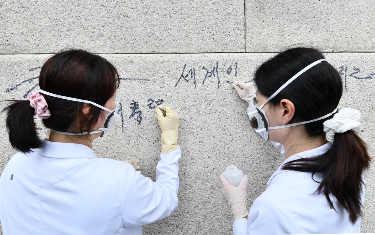 국립고궁박물관 유물과학과 관계자들이 11일 서울 경복궁 광화문 석축에 남은 낙서를 제거하고 있다. 국가유산청은 이날 오전 광화문 석축에 낙서를 한 79세 남성을 현장에서 확인해 경찰에 인계했다. 2025.8.11 국가유산청 제공