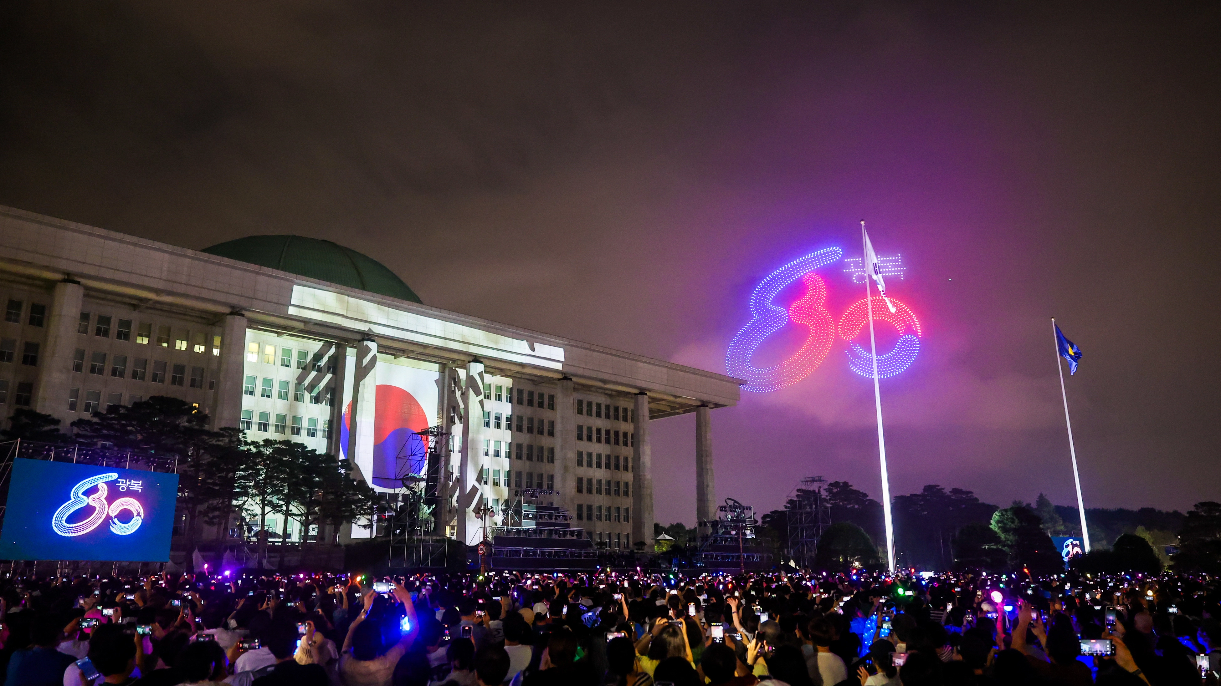 14일 국회의사당 앞 잔디광장에서 열린 광복80년 전야제 ‘대한이 살았다’에서 시민들이 공연을 관람하고 있다. 국가보훈부 제공