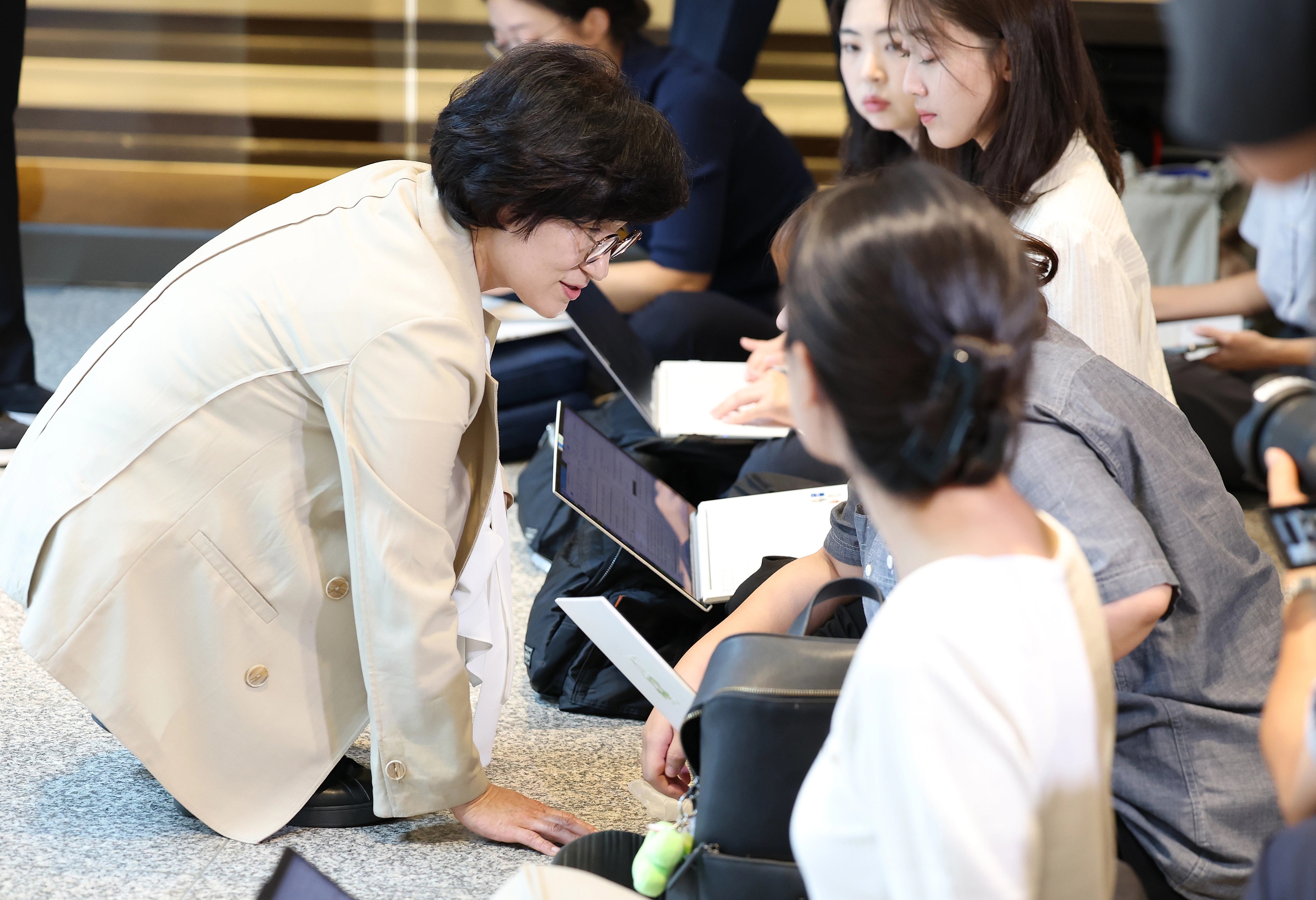 원민경 여성가족부 장관 후보자가 18일 오전 서울 서대문구 한국청소년활동진흥원에 마련된 인사청문 준비 사무실로 첫 출근하며 취재진과 질의응답을 마친 후 바닥에 앉은 여기자들의 업무 환경을 살피며 대화하고 있다. 2025.8.18/뉴스1