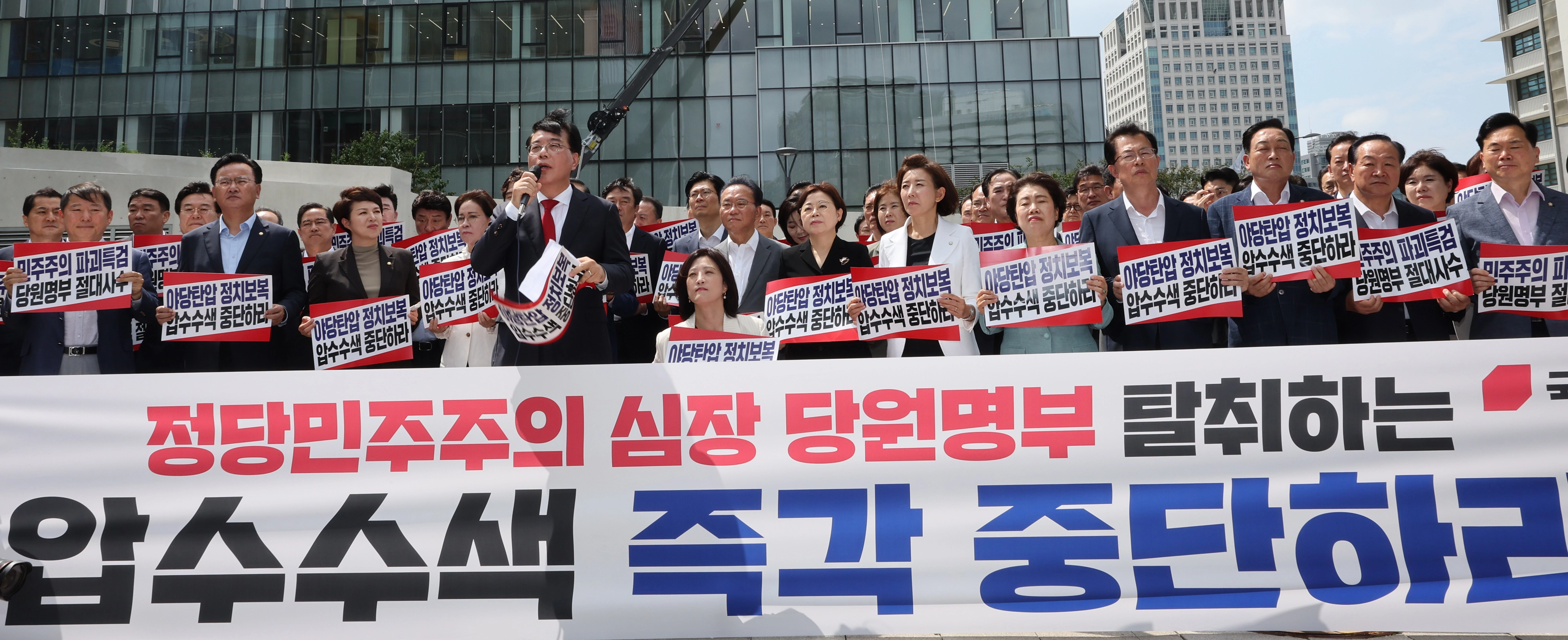 송언석 비대위원장 겸 원내대표를 비롯한 국민의힘 의원들이 18일 김건희 여사 관련 의혹을 수사하는 민중기 특별검사팀 사무실이 마련된 서울 종로구 KT 광화문빌딩 웨스트 앞에서 현장 비상 의원총회를 열고 야당탄압 정치보복 압수수색 규탄 구호를 외치고 있다. 연합뉴스