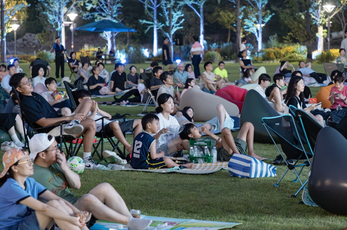 23일 의왕 백운호수공원 잔디광장에서 열린 ‘2025 우리동네 돗자리 영화관’ 첫 상영회에서 시민들이 영화를 관람하고 있다. (의왕시 제공)