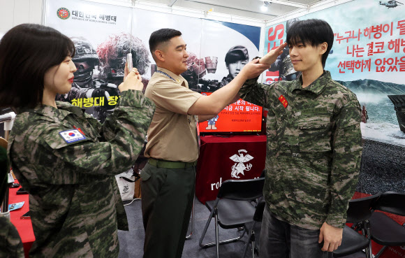 10일 경기도 수원시 영통구 수원컨벤션센터에서 열린 ‘2025 공직박람회’에서 해병대 부스를 찾은 관람객이 군복을 착용해보고 있다. 2025.9.10  연합뉴스