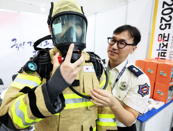 10일 경기도 수원시 영통구 수원컨벤션센터에서 열린 ‘2025 공직박람회’에서 소방청 부스를 찾은 관람객이 장비를 착용해보고 있다. 2025.9.10  연합뉴스